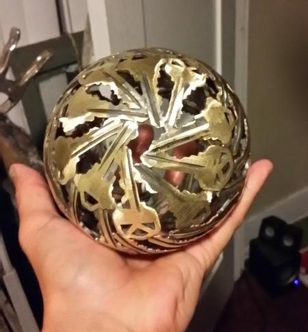 A small brass sphere held in one hand