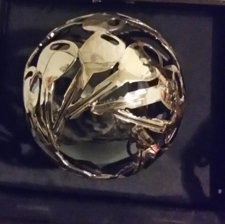 A silver sphere assembled from curved recovered pieces